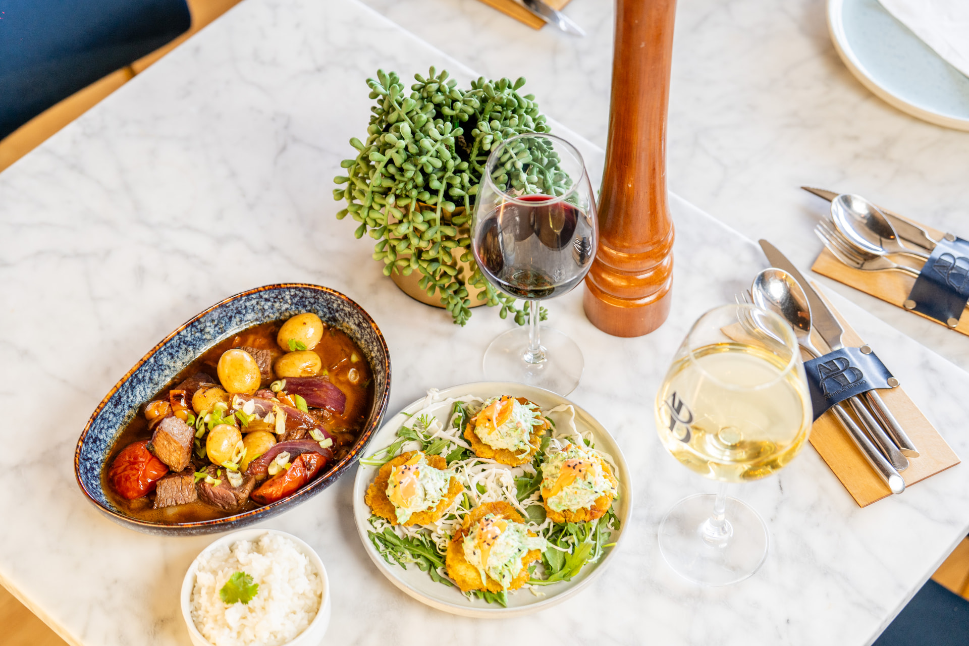 Table spread with lomo saltado, patacón bites and red and white wine