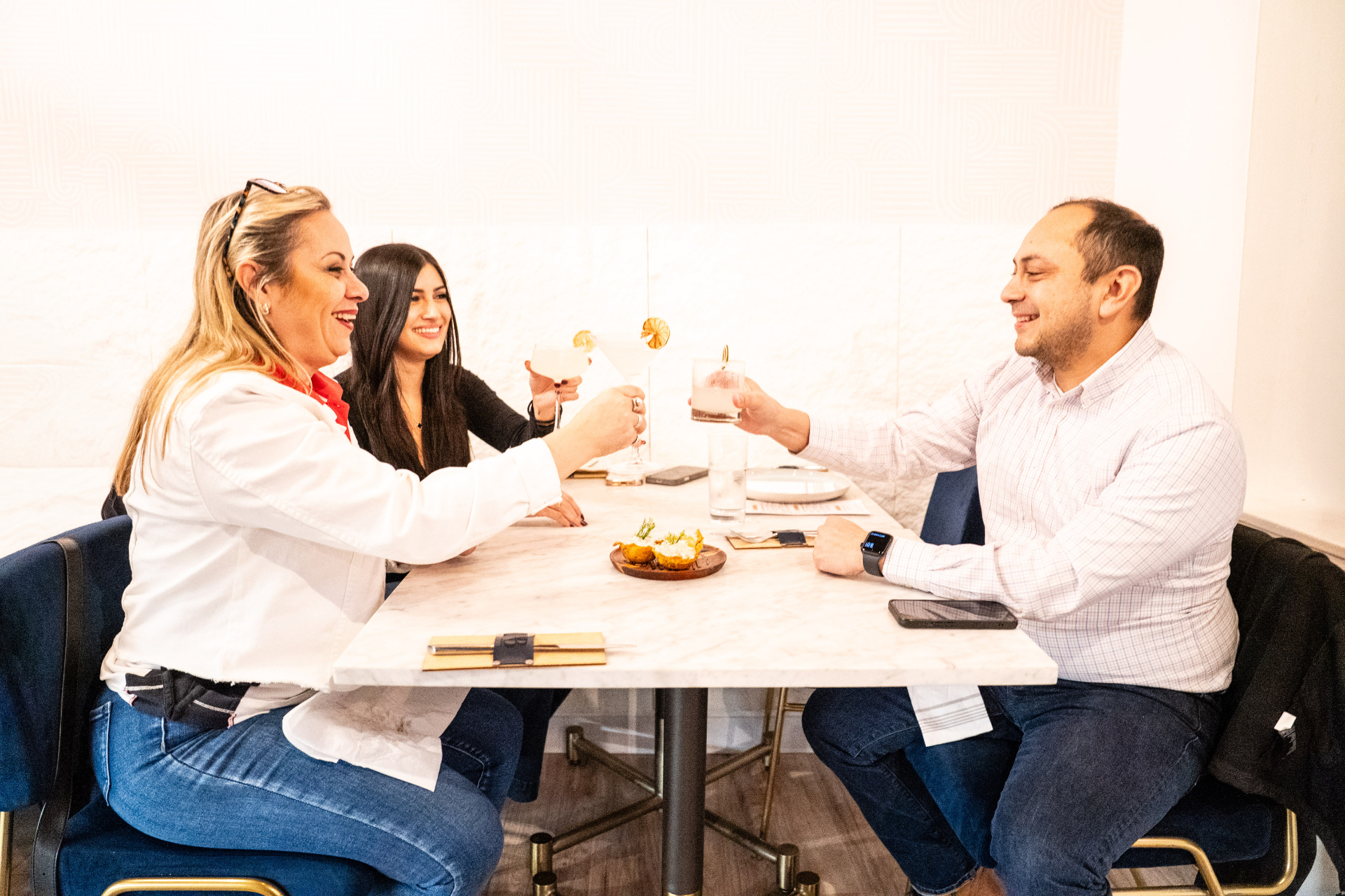 Guests cheering and sharing a meal at Anhelo Bistro