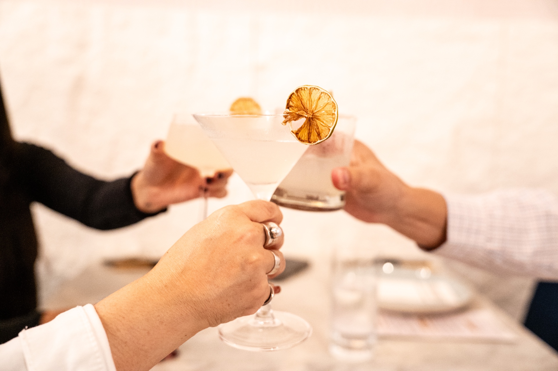 Friends toasting cocktails at Anhelo Bistro